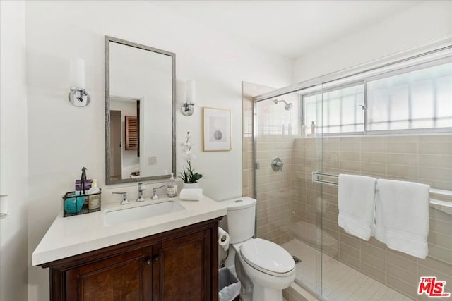 bathroom with toilet, vanity, and walk in shower