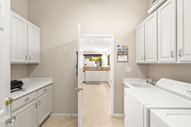 washroom with washing machine and dryer, sink, light tile patterned floors, and cabinets