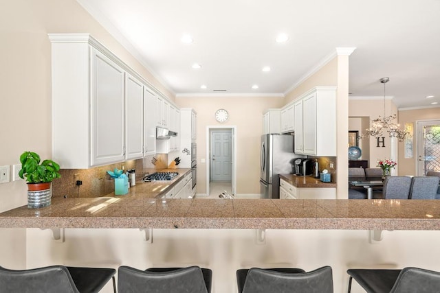 kitchen with kitchen peninsula, a breakfast bar, and white cabinetry