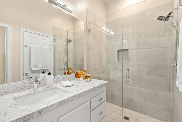 bathroom featuring a shower with door and vanity