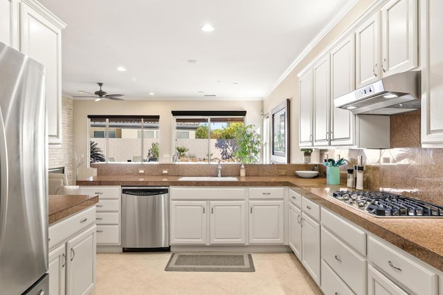 kitchen featuring kitchen peninsula, white cabinets, stainless steel appliances, and ornamental molding