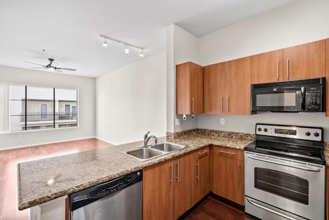 kitchen with sink, dark wood-type flooring, ceiling fan, stainless steel appliances, and kitchen peninsula