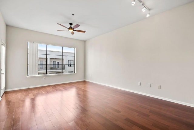 spare room with hardwood / wood-style flooring, rail lighting, and ceiling fan