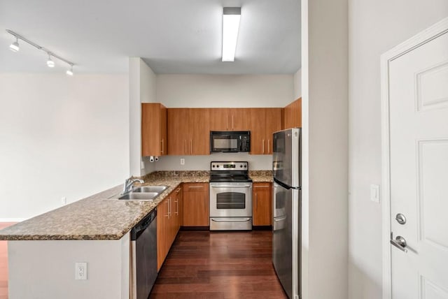 kitchen featuring sink, stainless steel appliances, light stone counters, dark hardwood / wood-style flooring, and kitchen peninsula