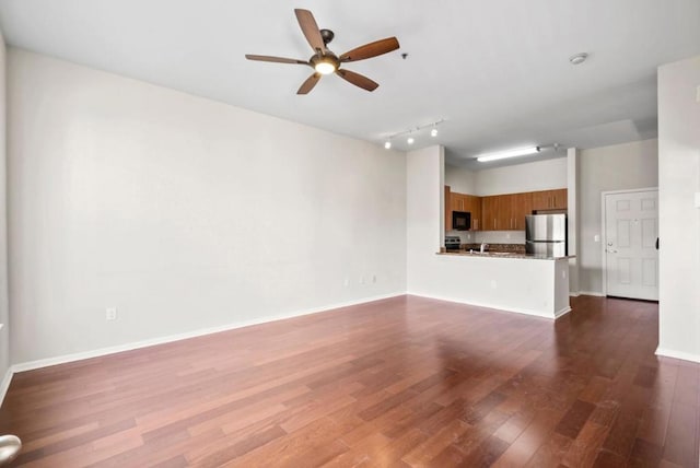 unfurnished living room with ceiling fan and dark hardwood / wood-style floors