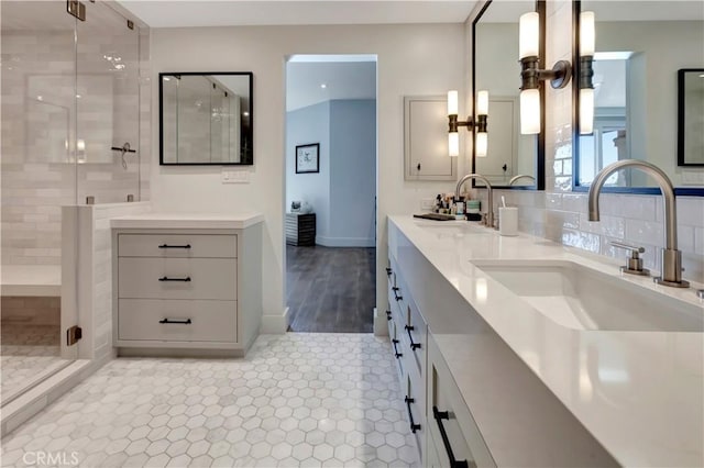 bathroom featuring a shower with door and vanity