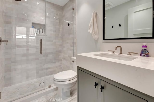 bathroom with toilet, an enclosed shower, and vanity