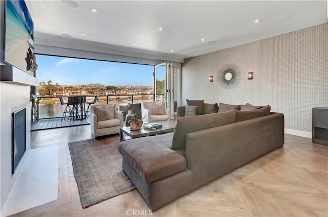 living room with light parquet flooring and a wall of windows