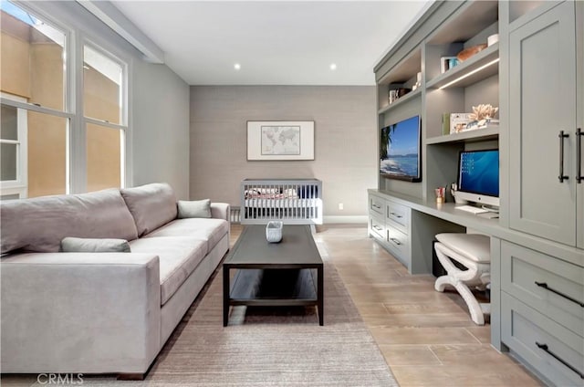 living room featuring built in features, built in desk, and light hardwood / wood-style flooring