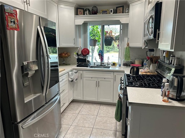 kitchen featuring white cabinets, light tile patterned floors, sink, and appliances with stainless steel finishes