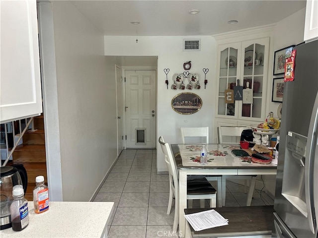 kitchen featuring stainless steel fridge with ice dispenser, white cabinets, and light tile patterned floors