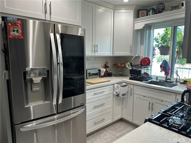 kitchen featuring white cabinets, light stone countertops, and stainless steel fridge with ice dispenser