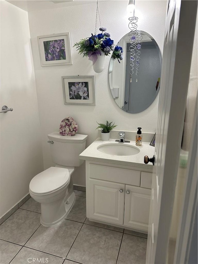 bathroom with tile patterned flooring, vanity, and toilet