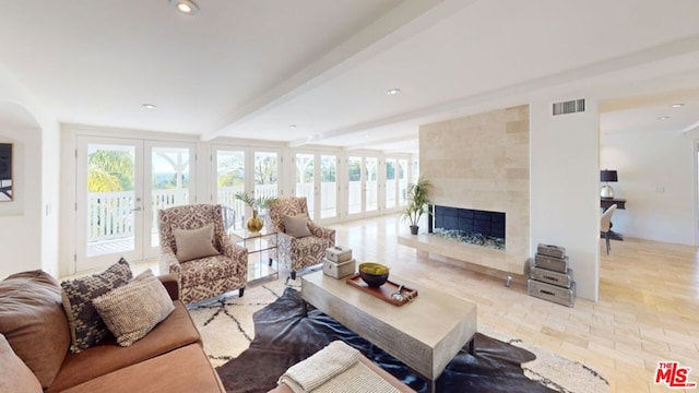 living room featuring a fireplace, beamed ceiling, and french doors