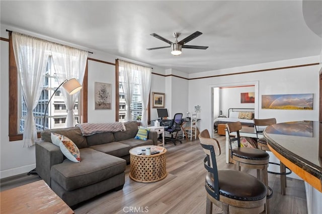 living room with ceiling fan and light wood-type flooring