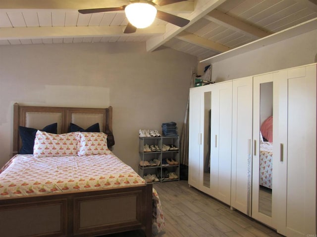 bedroom featuring hardwood / wood-style floors, ceiling fan, and lofted ceiling with beams