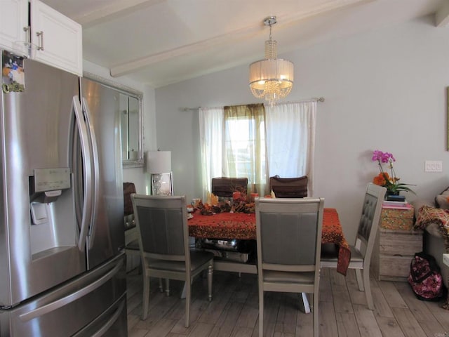 dining room featuring hardwood / wood-style floors, lofted ceiling with beams, and a notable chandelier