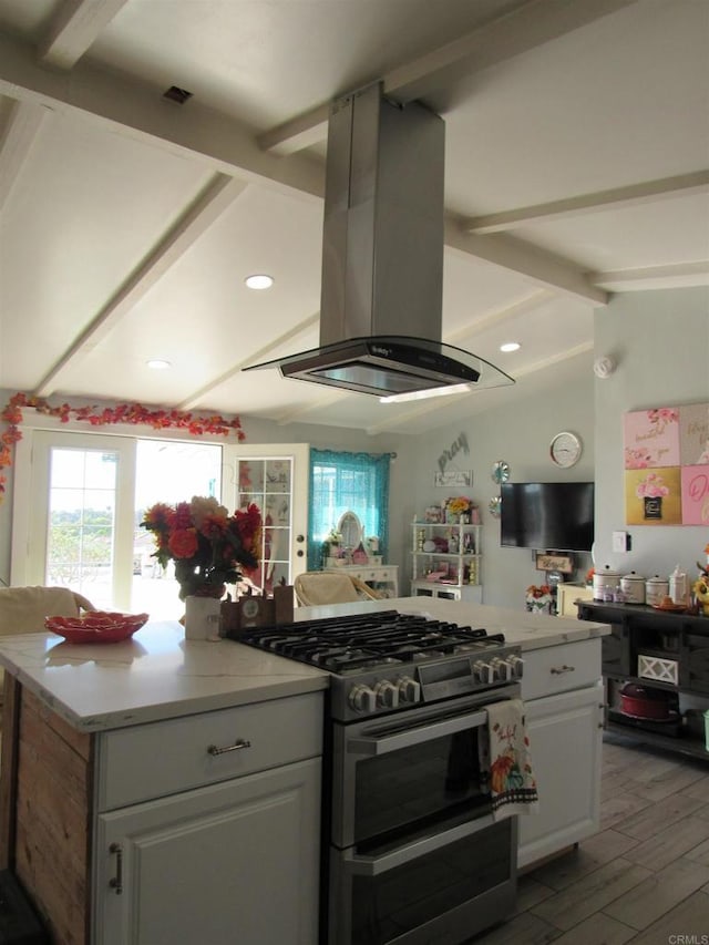 kitchen with stainless steel range, island range hood, lofted ceiling with beams, hardwood / wood-style flooring, and white cabinetry