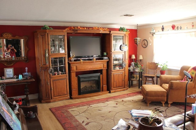 living room featuring light wood-type flooring and crown molding