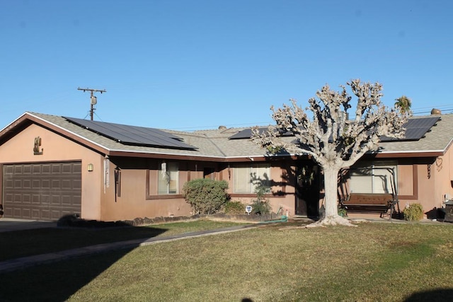 single story home featuring solar panels, a front yard, and a garage