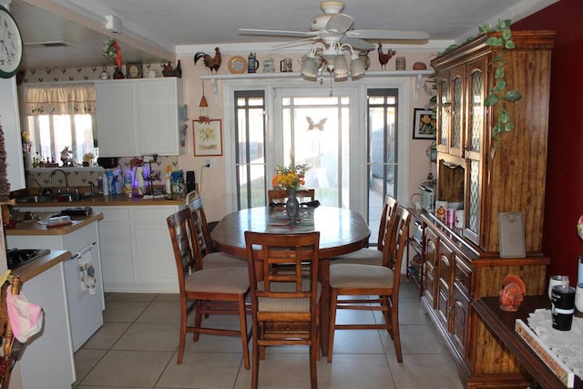 tiled dining area with ceiling fan and sink