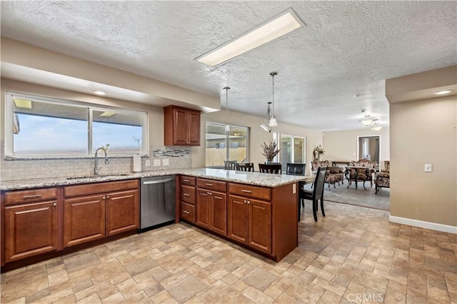 kitchen featuring pendant lighting, dishwasher, sink, decorative backsplash, and kitchen peninsula