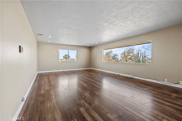 unfurnished room featuring a textured ceiling and dark hardwood / wood-style floors