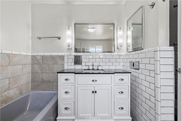 bathroom with vanity, a bath, and tile walls