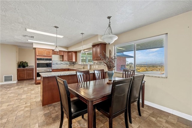 dining area featuring sink and a textured ceiling