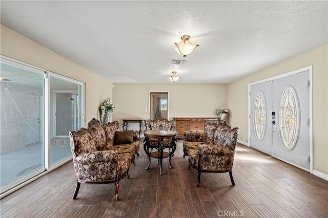 living room featuring a healthy amount of sunlight, a textured ceiling, and wood-type flooring