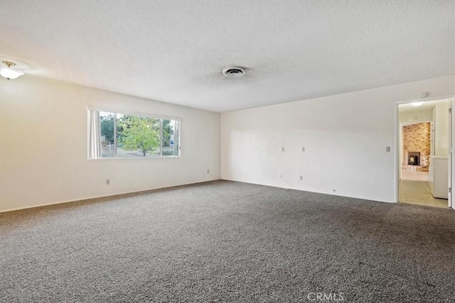 carpeted empty room with a textured ceiling