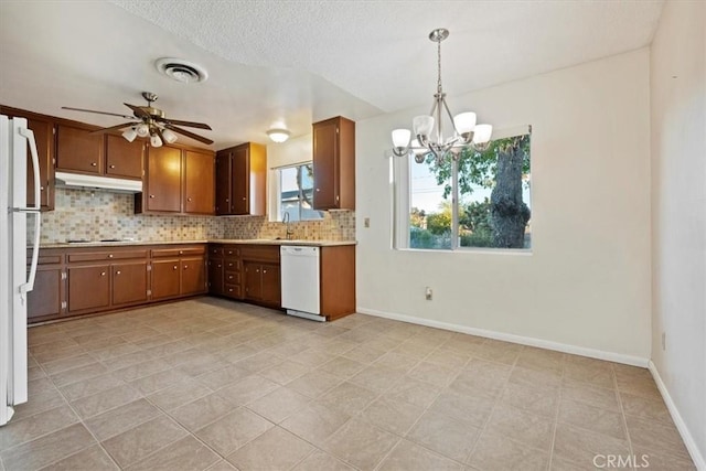 kitchen with tasteful backsplash, ceiling fan with notable chandelier, white appliances, pendant lighting, and light tile patterned floors