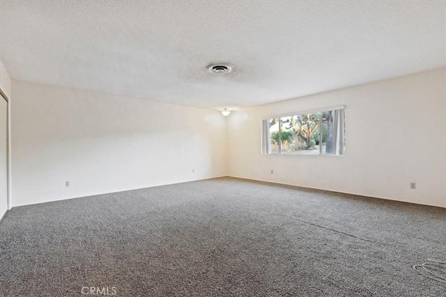 empty room featuring carpet floors and a textured ceiling