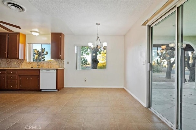 kitchen featuring dishwasher, backsplash, ceiling fan with notable chandelier, hanging light fixtures, and a textured ceiling