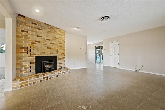 unfurnished living room with tile patterned flooring and a textured ceiling