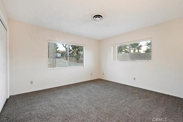 unfurnished room featuring carpet and plenty of natural light