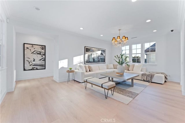 living room featuring a chandelier, crown molding, and light hardwood / wood-style flooring