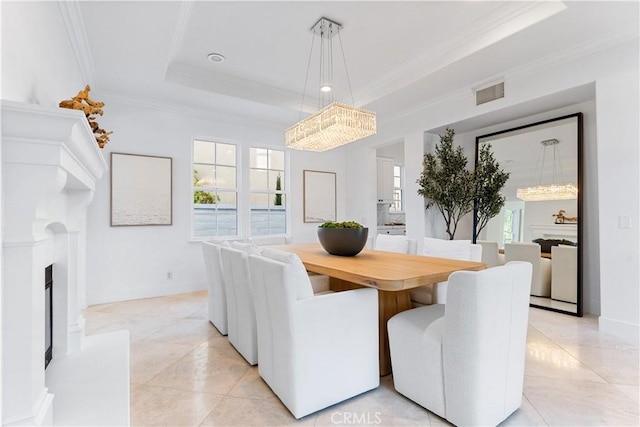 dining space featuring a tray ceiling, crown molding, light tile patterned flooring, and a notable chandelier