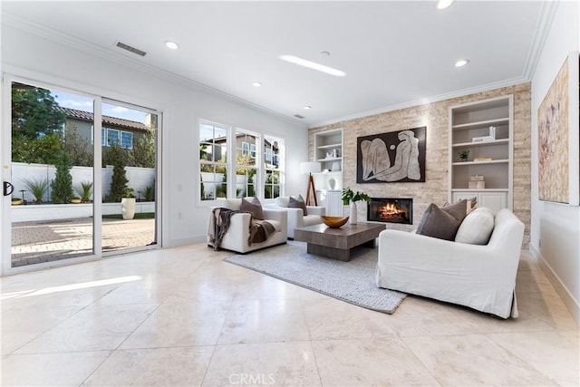 living room featuring built in shelves, crown molding, a fireplace, and light tile patterned flooring