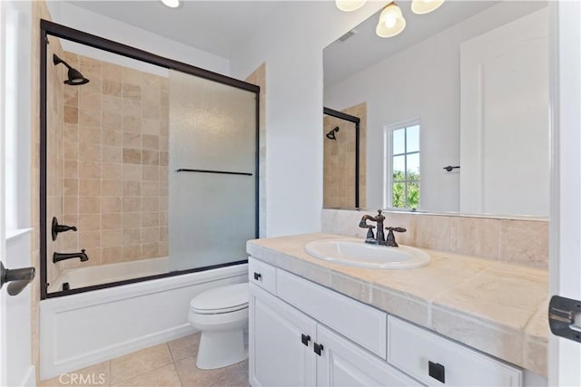 full bathroom with tile patterned floors, vanity, toilet, and shower / bath combination with glass door