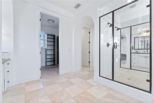 bathroom with vanity, an enclosed shower, and ornamental molding