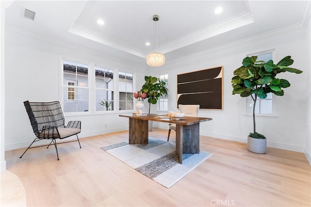 office featuring light hardwood / wood-style floors, a raised ceiling, and ornamental molding