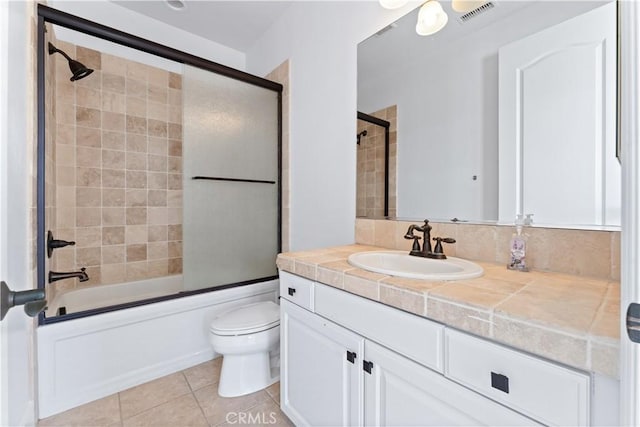 full bathroom with tile patterned flooring, vanity, enclosed tub / shower combo, and toilet