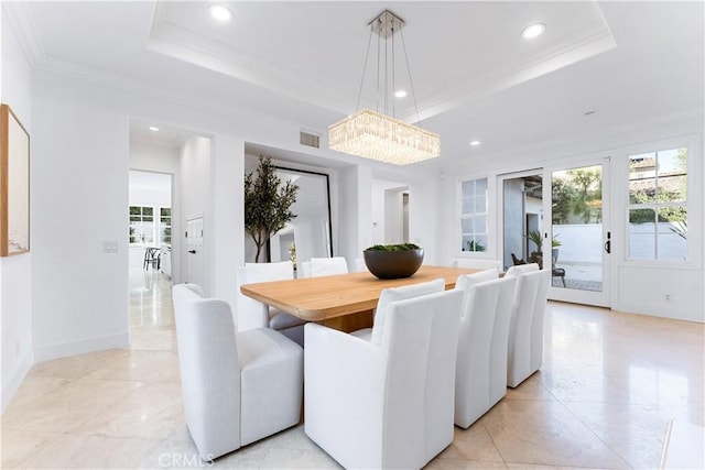 dining space with french doors, crown molding, and a tray ceiling