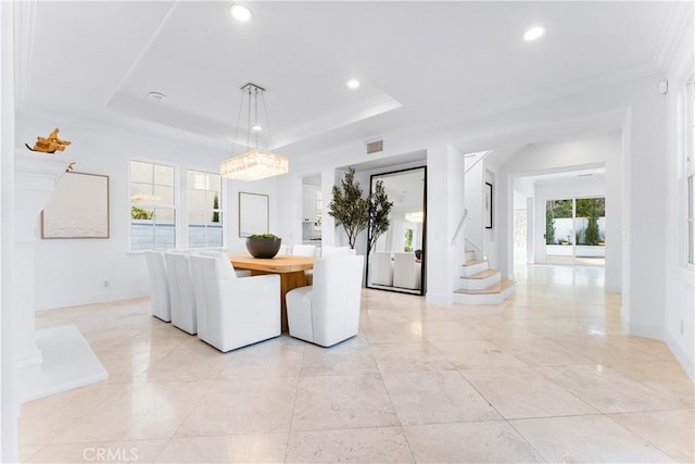 unfurnished dining area with ornamental molding, a wealth of natural light, and a tray ceiling