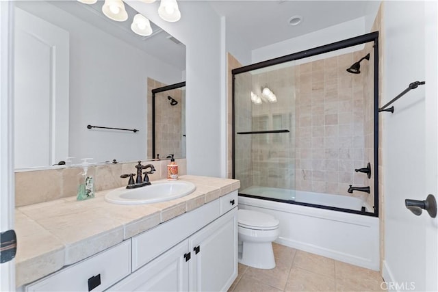 full bathroom with tile patterned flooring, vanity, toilet, and shower / bath combination with glass door