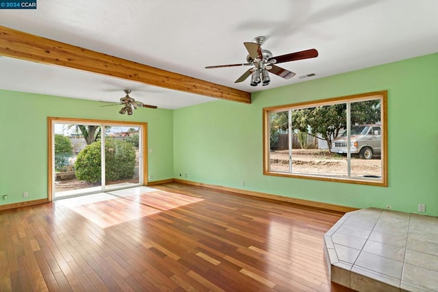 empty room with beam ceiling, hardwood / wood-style flooring, and ceiling fan