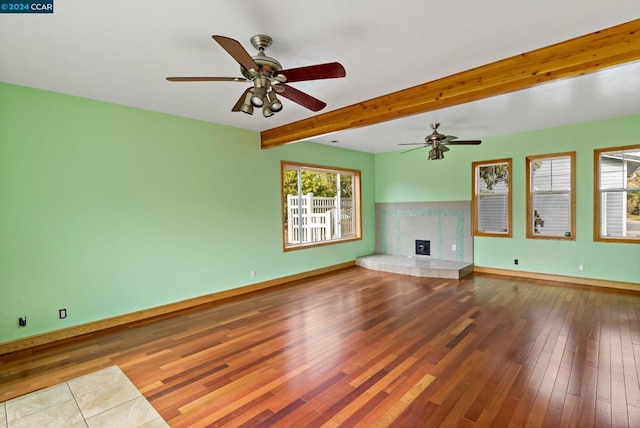 unfurnished living room featuring ceiling fan, beamed ceiling, and hardwood / wood-style flooring