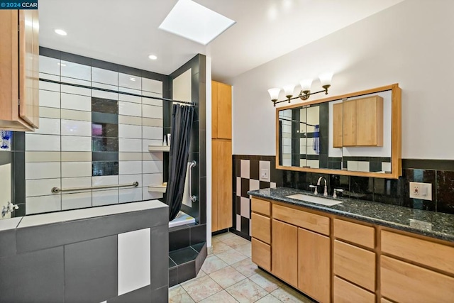 bathroom with tile patterned flooring, vanity, a skylight, and walk in shower