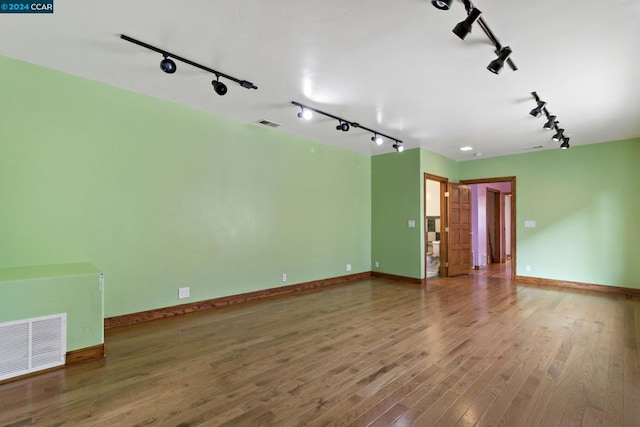 spare room featuring wood-type flooring and track lighting